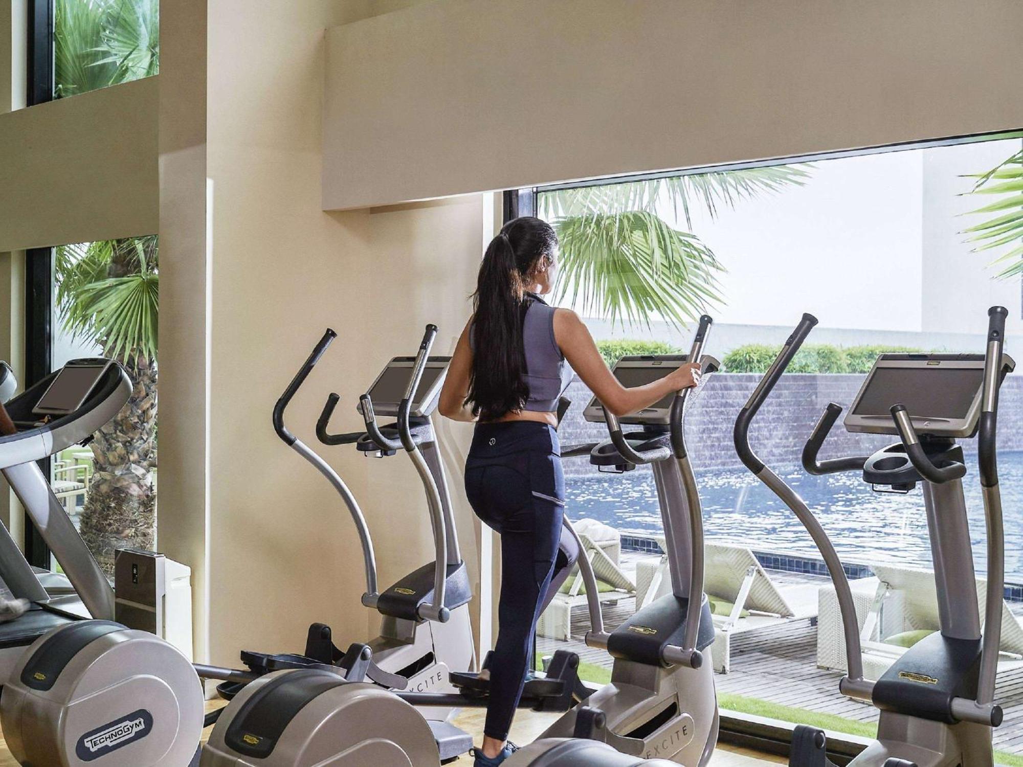 Pullman New Delhi Aerocity Exteriör bild A woman on an elliptical trainer